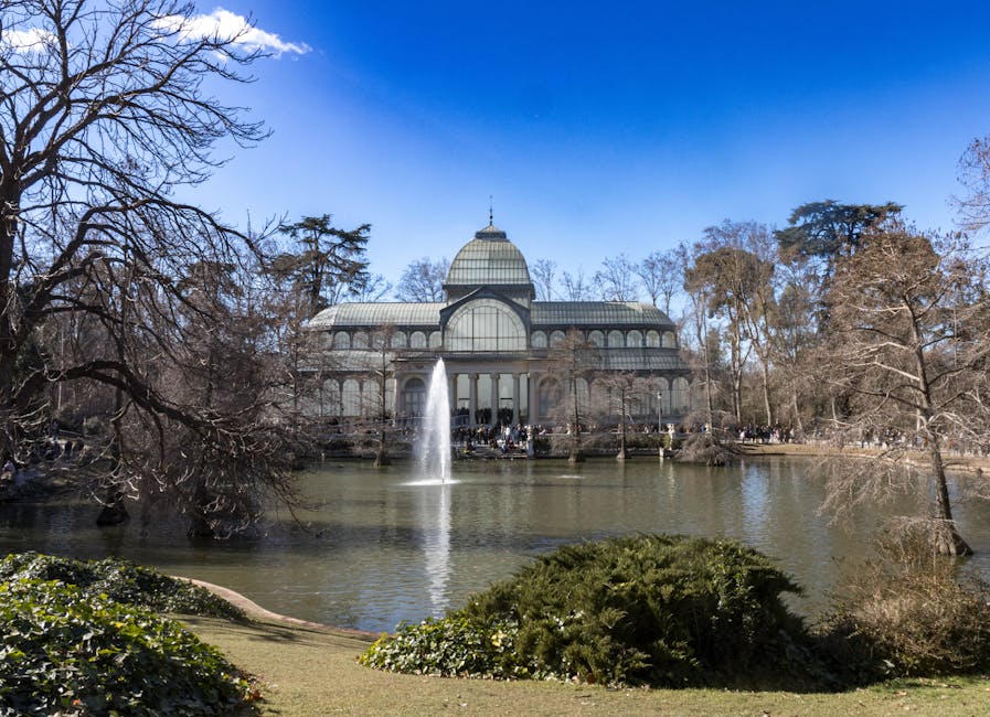 Palacio de Cristal Crystal Palace in Retiro Park Madrid reflecting on pond
