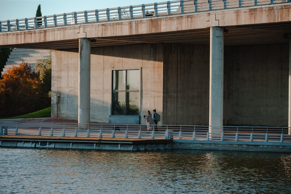 Madrid Rio linear park riverside walking path beneath modern bridge