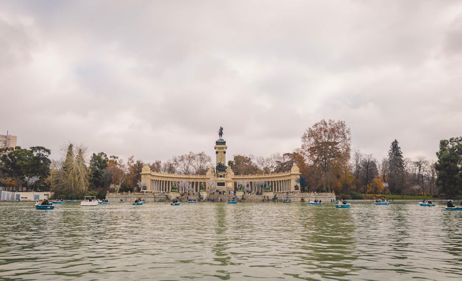 Rowing boats on Retiro Park lake with autumn trees in background
